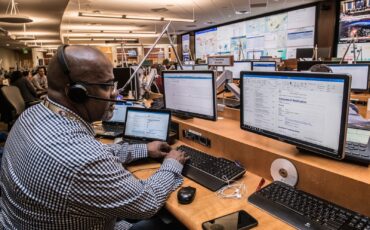 man in black and white checkered dress shirt using computer